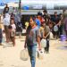 Palestinian children carrying water containers in a Gaza refugee camp under the summer sun, highlighting the region's clean water crisis.