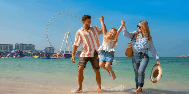 A smiling family enjoys a summer vacation in Dubai with iconic skyscrapers and sunny weather in the background.
